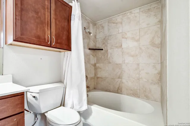 a white toilet sitting next to a bath tub
