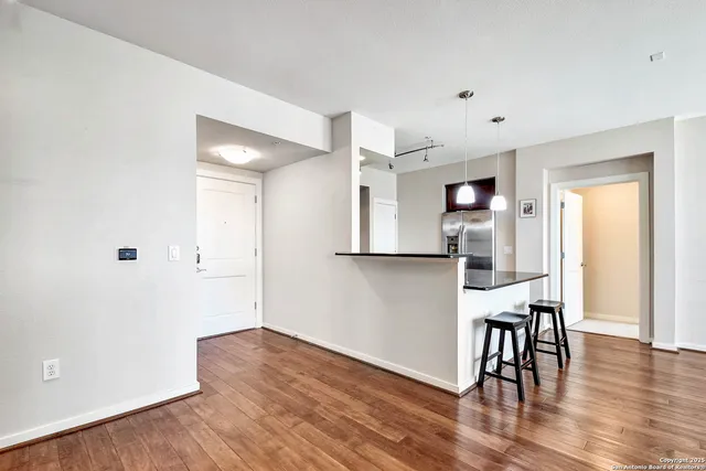 a view of a kitchen with wooden floor and a refrigerator
