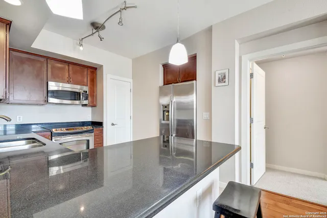 a kitchen with stainless steel appliances granite countertop a sink and a refrigerator