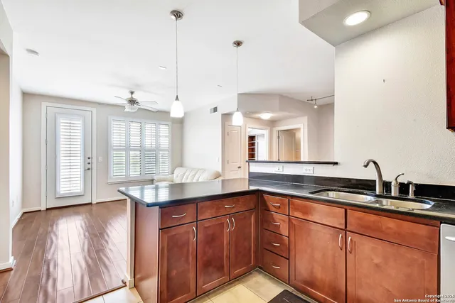 a kitchen with stainless steel appliances granite countertop a sink a oven and a granite counter tops with white cabinets