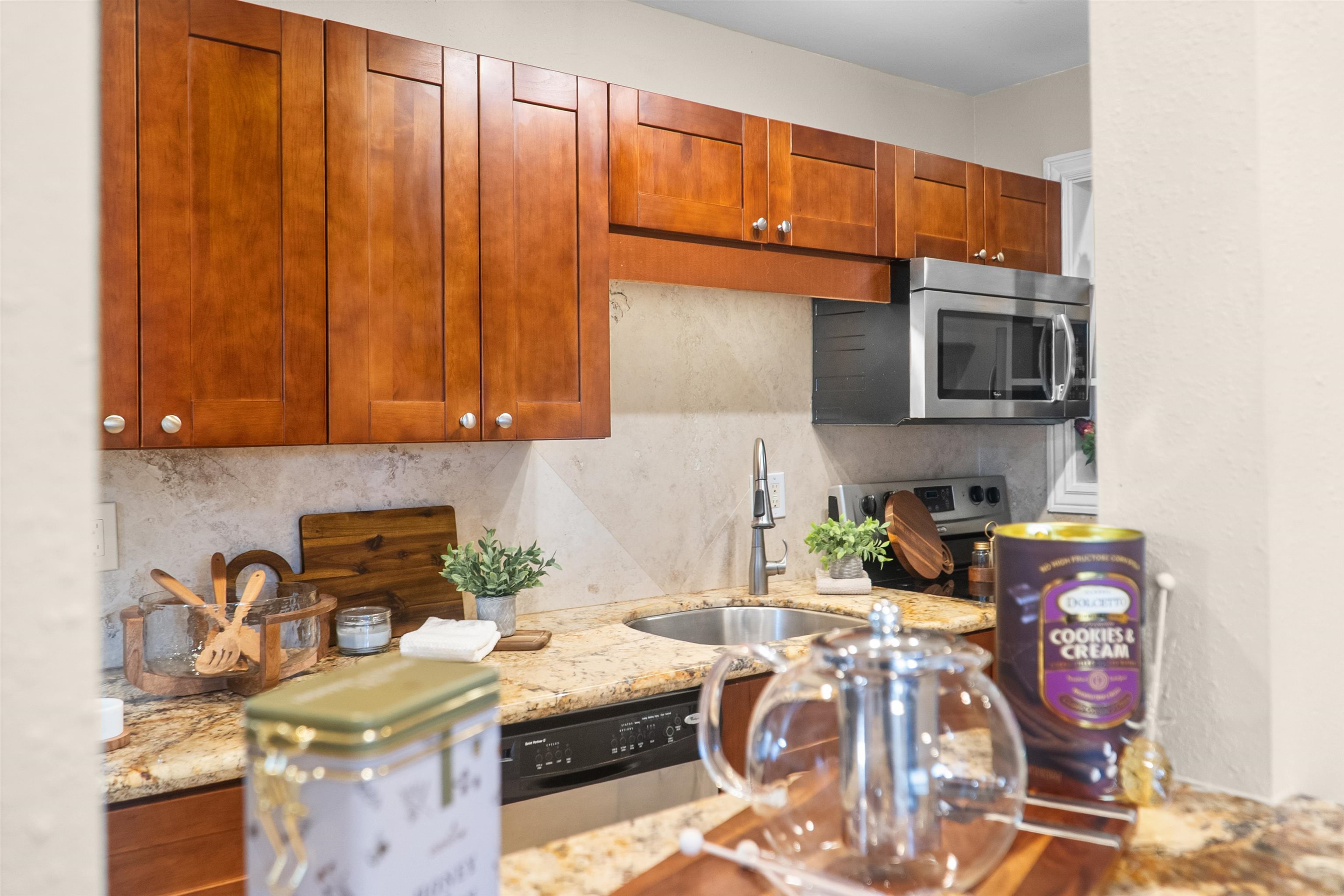 480 Kenolio Road, Unit 1203 Kihei, HI 96753 - Photo 7 of 17 a kitchen with stainless steel appliances granite countertop a sink stove and microwave