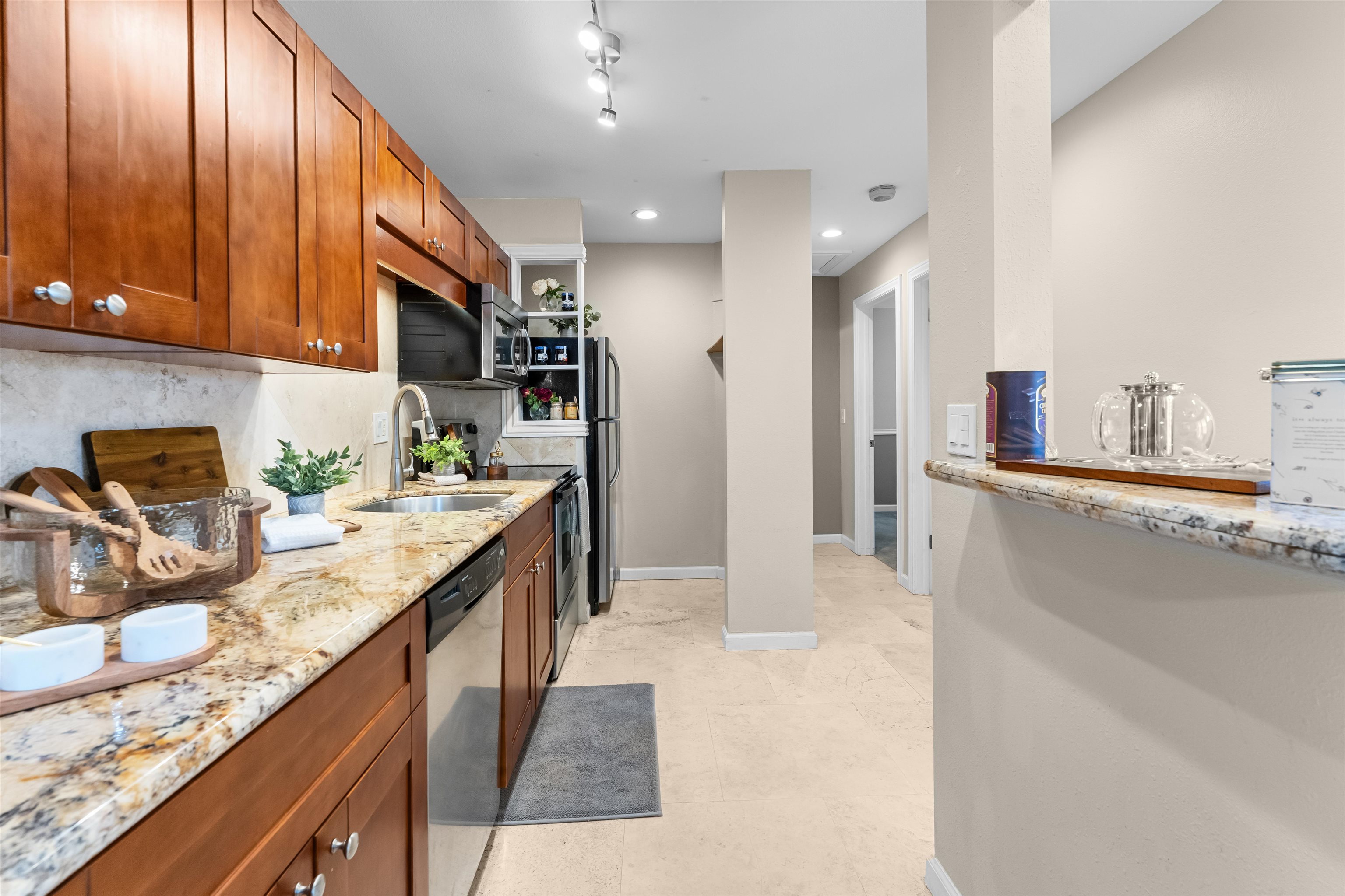 480 Kenolio Road, Unit 1203 Kihei, HI 96753 - Photo 8 of 17 a kitchen with stainless steel appliances granite countertop a sink stove and refrigerator