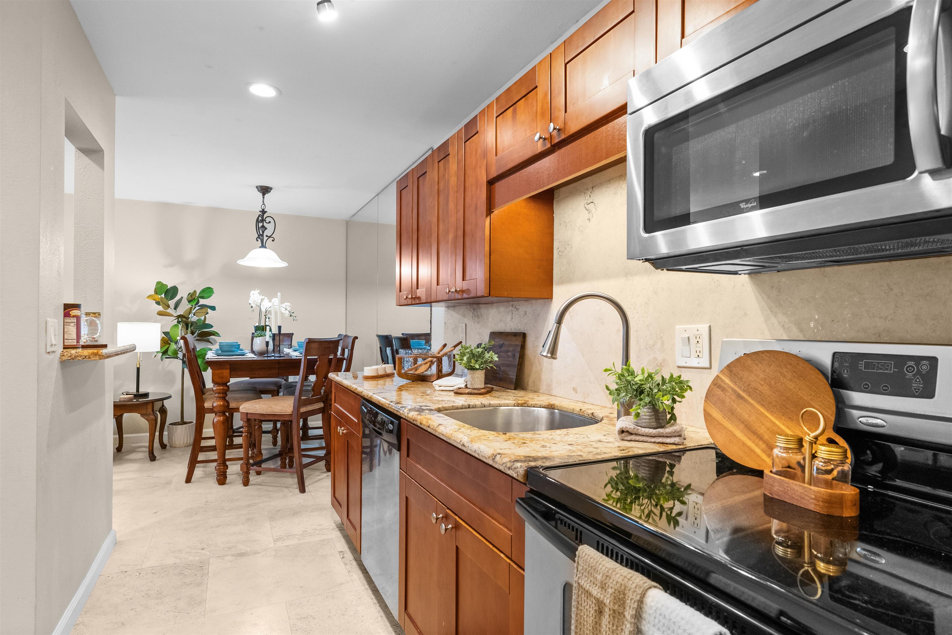 480 Kenolio Road, Unit 1203 Kihei, HI 96753 - Photo 9 of 17 a kitchen with a stove and a dining table