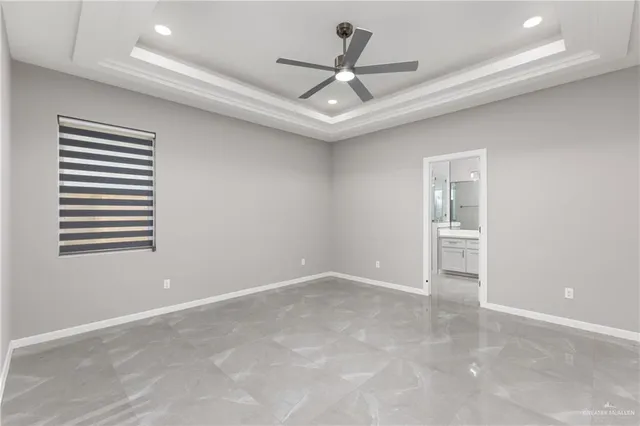 an empty room with windows and ceiling fan