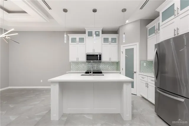 a kitchen with kitchen island a stove top oven and refrigerator