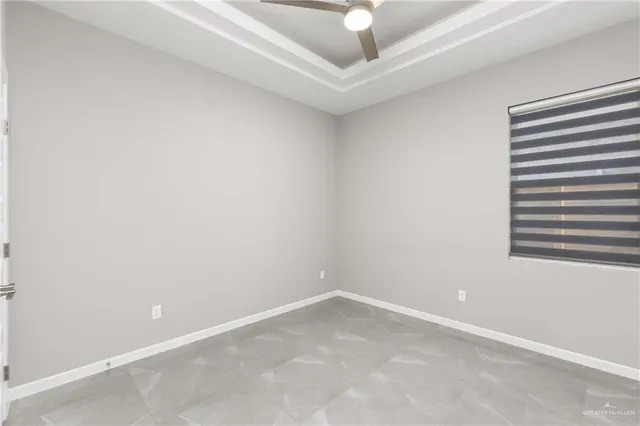 an empty room with a ceiling fan and a window