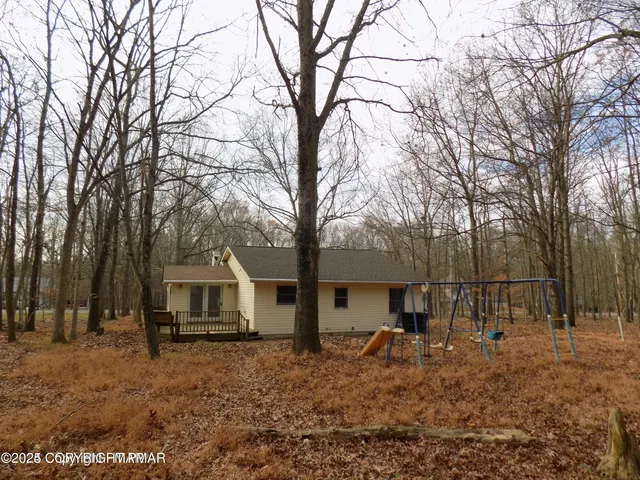 a backyard of a house with barbeque oven table and chairs