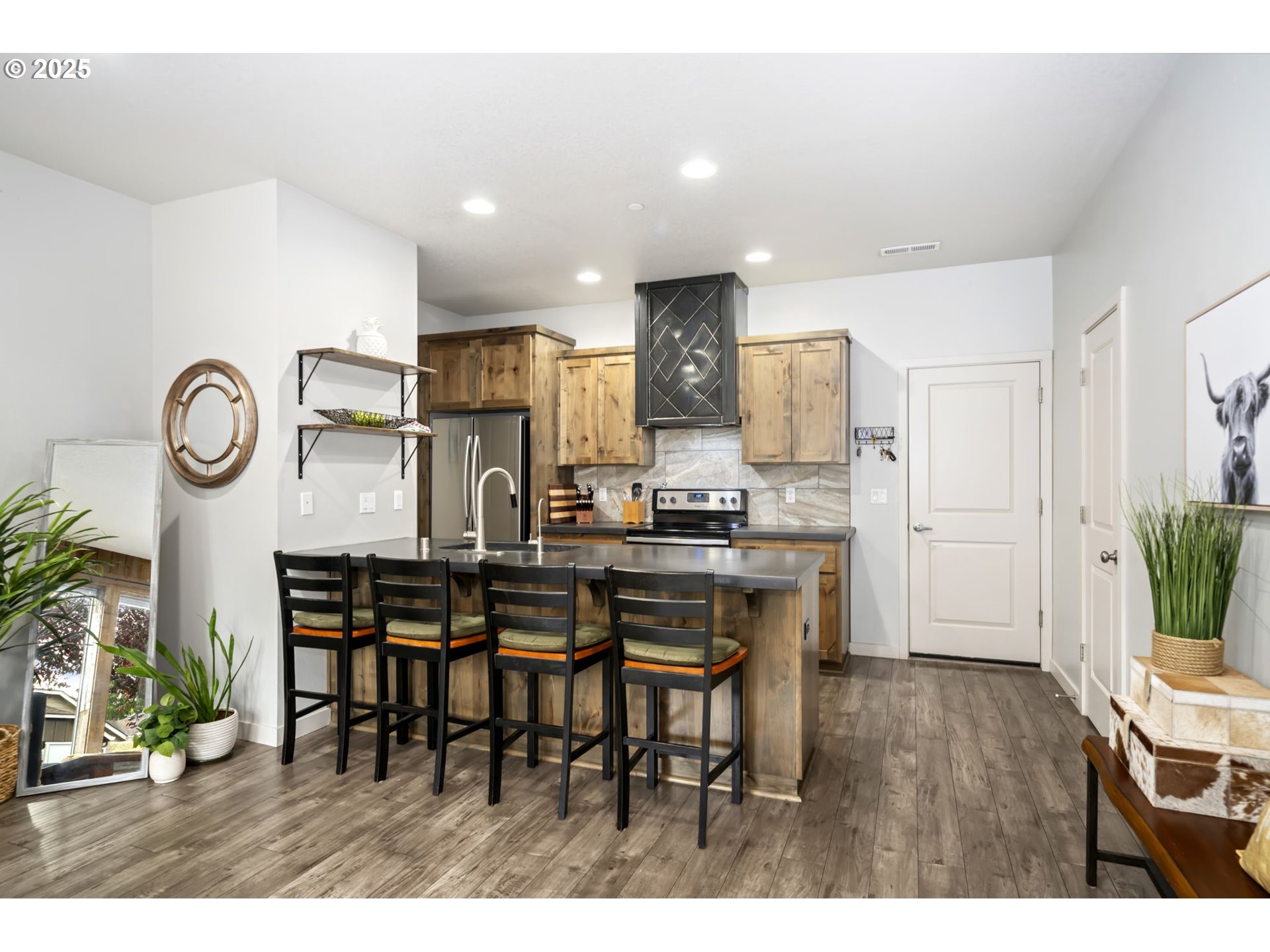 125 North 44th Place Ridgefield, WA 98642 - Photo 18 of 47 a open kitchen with stainless steel appliances kitchen island granite countertop a table chairs and a refrigerator