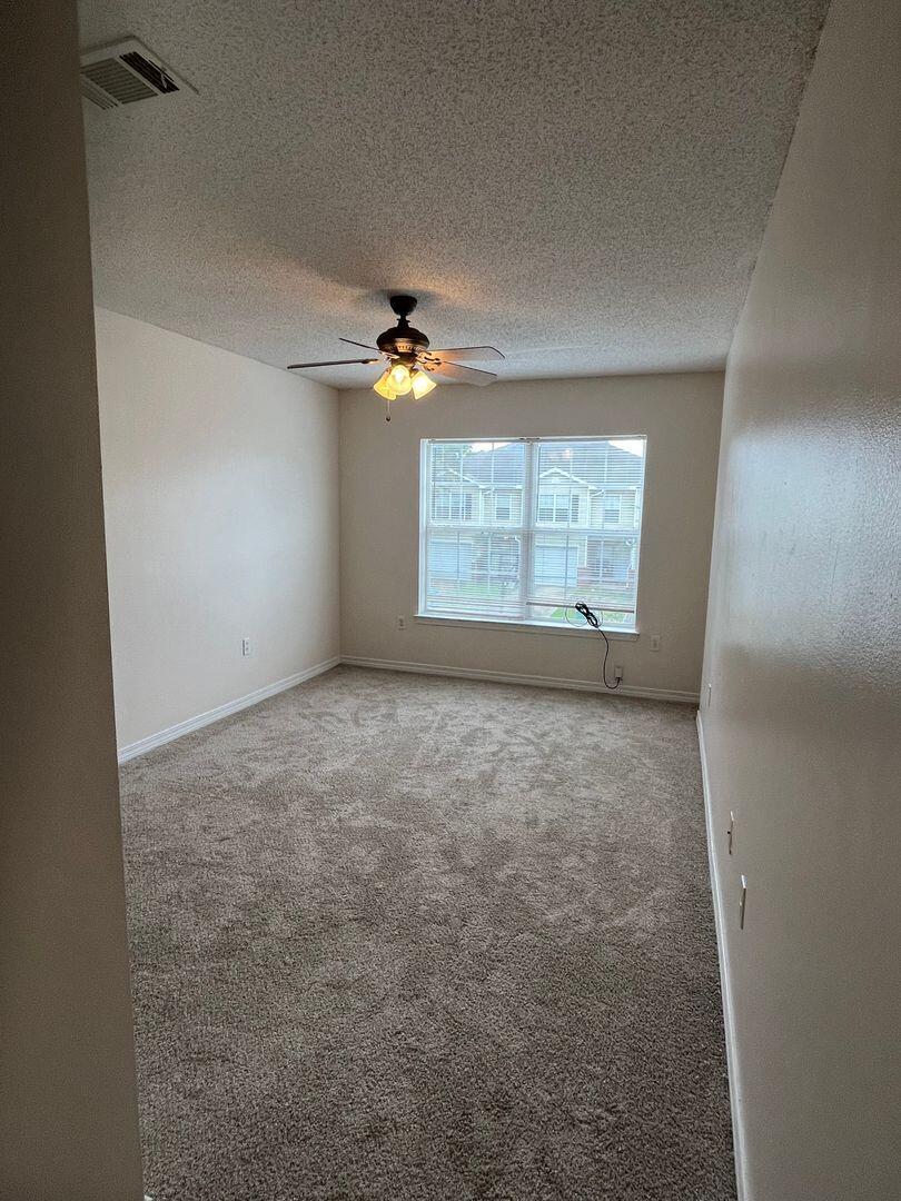 202 Johnson Court Crestview, FL 32536 - Photo 18 of 24 an empty room with windows and fan
