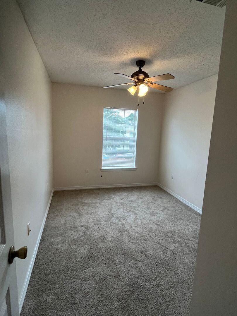 202 Johnson Court Crestview, FL 32536 - Photo 21 of 24 an empty room with windows and fan
