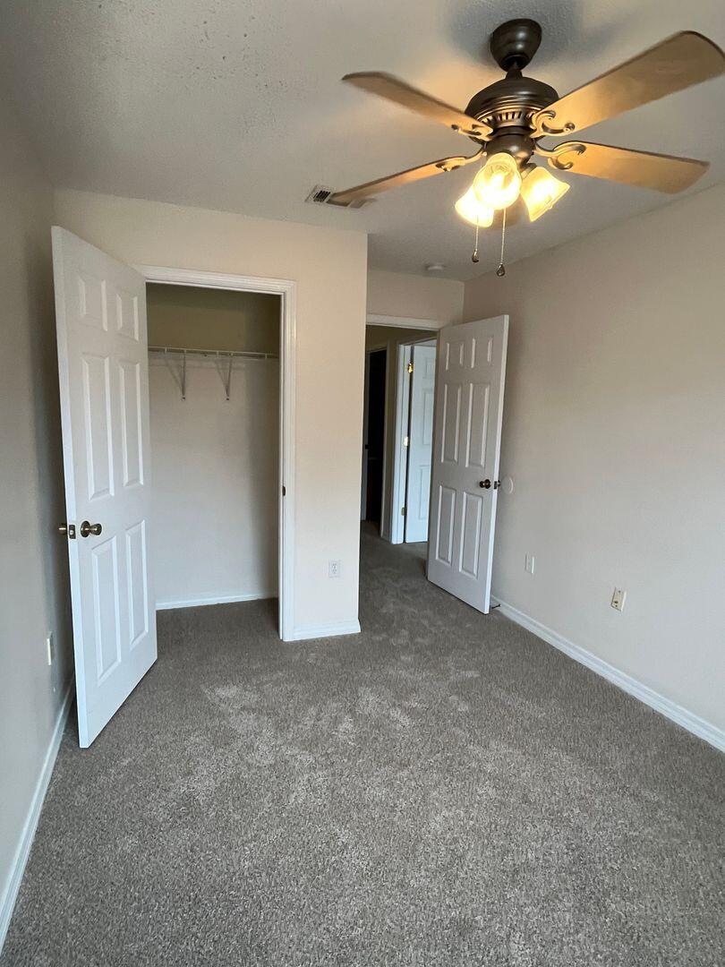 202 Johnson Court Crestview, FL 32536 - Photo 22 of 24 an empty room with closet and a chandelier fan