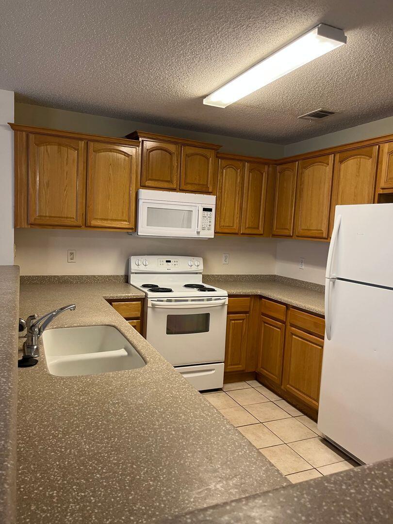 202 Johnson Court Crestview, FL 32536 - Photo 5 of 24 a kitchen with a sink stove and refrigerator