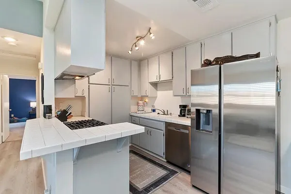 a kitchen with kitchen island a counter top space a sink stainless steel appliances and cabinets