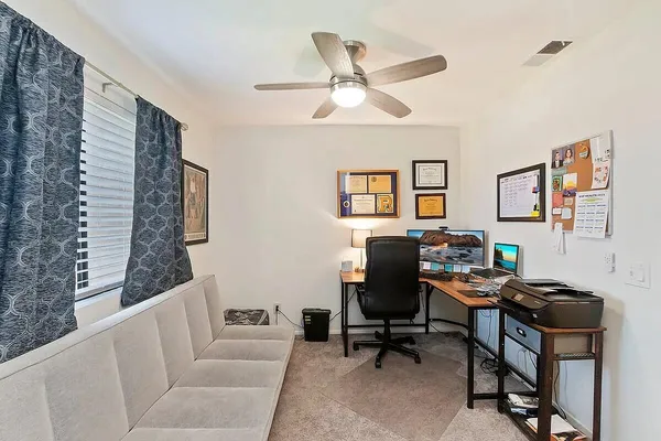 a view of a workspace with furniture and a window