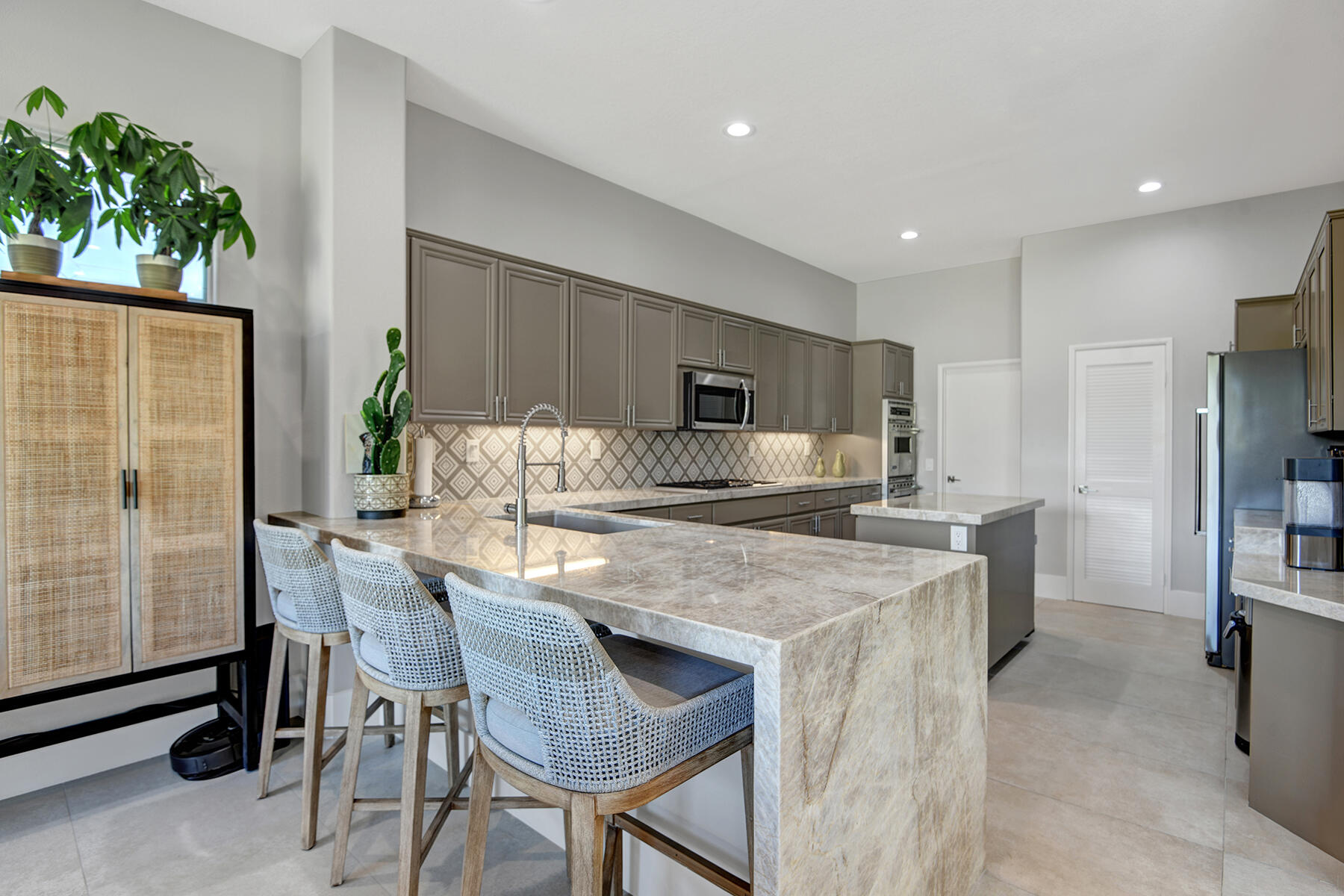 75 North Kavenish Drive Rancho Mirage, CA 92270 - Photo 11 of 41 a kitchen with kitchen island a table and chairs in it
