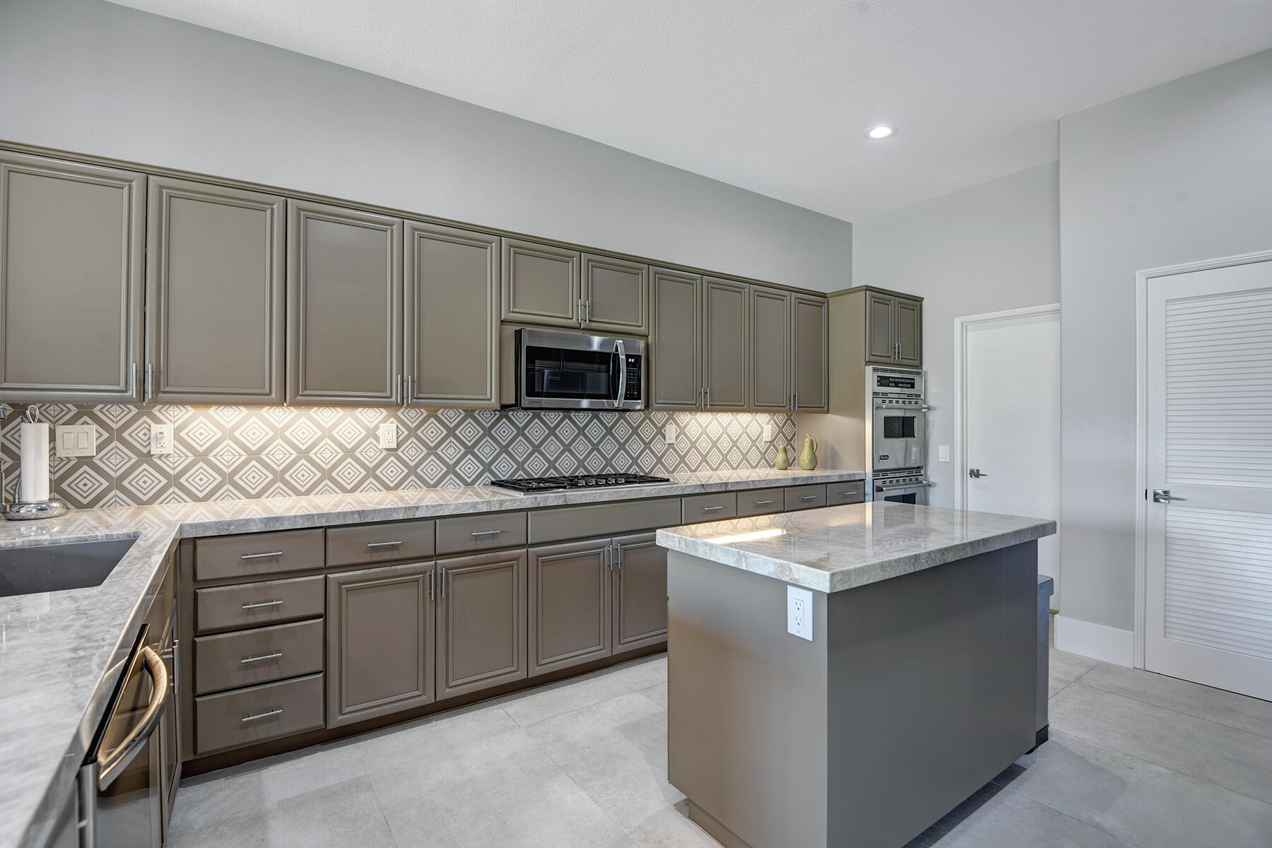 75 North Kavenish Drive Rancho Mirage, CA 92270 - Photo 13 of 41 a kitchen with stainless steel appliances granite countertop a sink stove and microwave