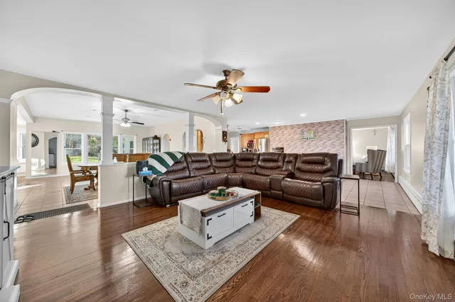 a living room with furniture and a ceiling fan