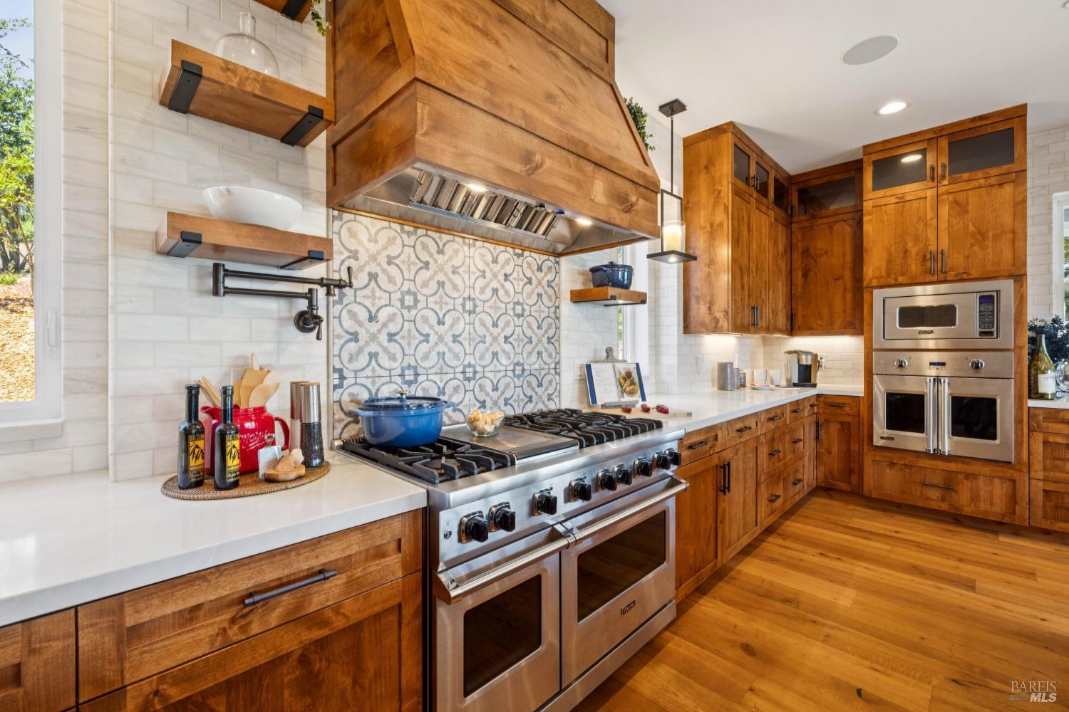 3882 Royal Manor Place Santa Rosa, CA 95404 - Photo 21 of 98 Cook for 2 or 20 in this chef's dream kitchen, featuring 48” Viking range with 6 burners + griddle and two ovens, a separate electric oven for the bakers, a large built-in Sub-Zero refrigerator, and a large built-in Sub-Zero freezer, pot filler, quartz counters, marble backsplash, Viking dishwasher, microwave, Kraus stainless steel sink with custom cutting board, drying rack and drain racks, beautiful customs alder cabinets, recessed lighting, surround sound and more.