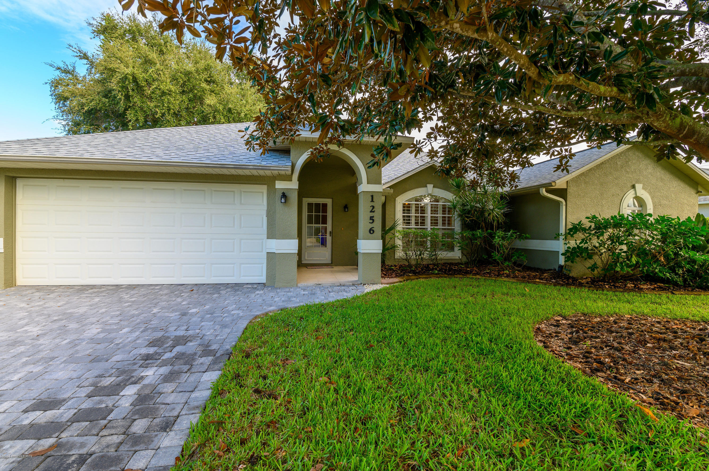 1256 Winding Meadows Road Rockledge, FL 32955 - Photo 1 of 23 a front view of a house with a garden and trees