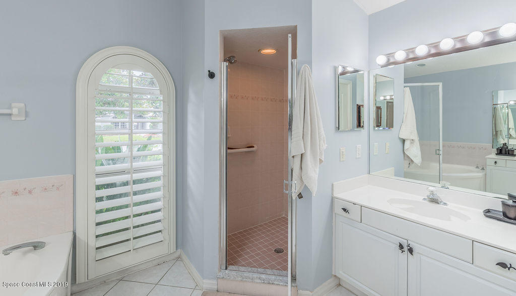 1256 Winding Meadows Road Rockledge, FL 32955 - Photo 13 of 23 a bathroom with a sink a vanity a window and a mirror