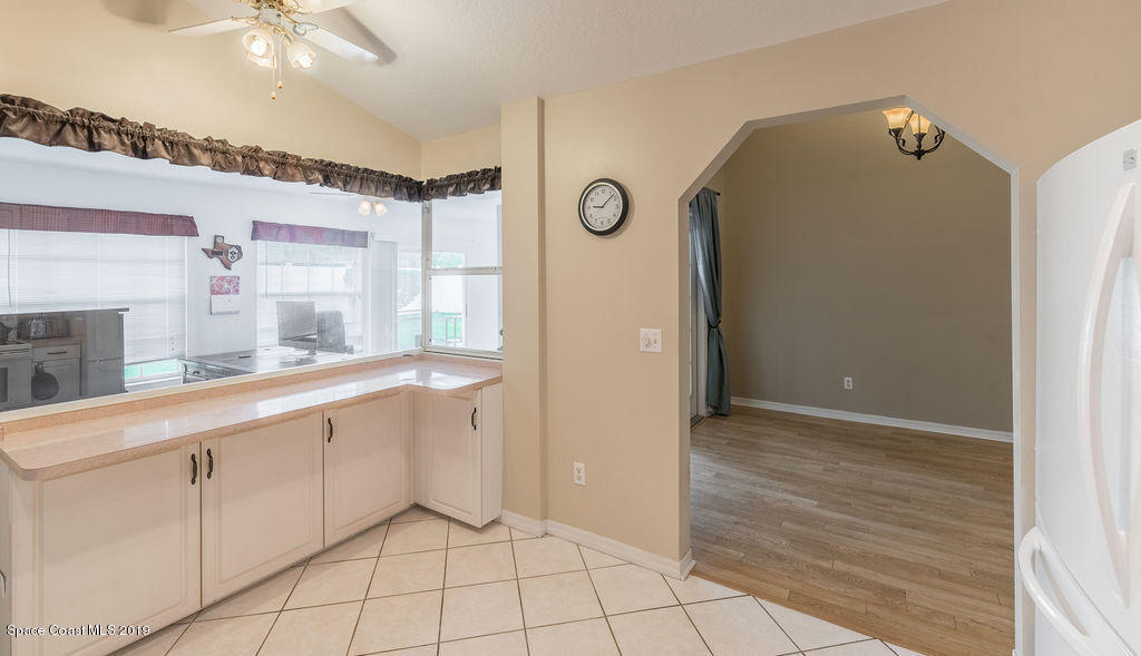 1256 Winding Meadows Road Rockledge, FL 32955 - Photo 7 of 23 a large white kitchen with cabinets and a refrigerator