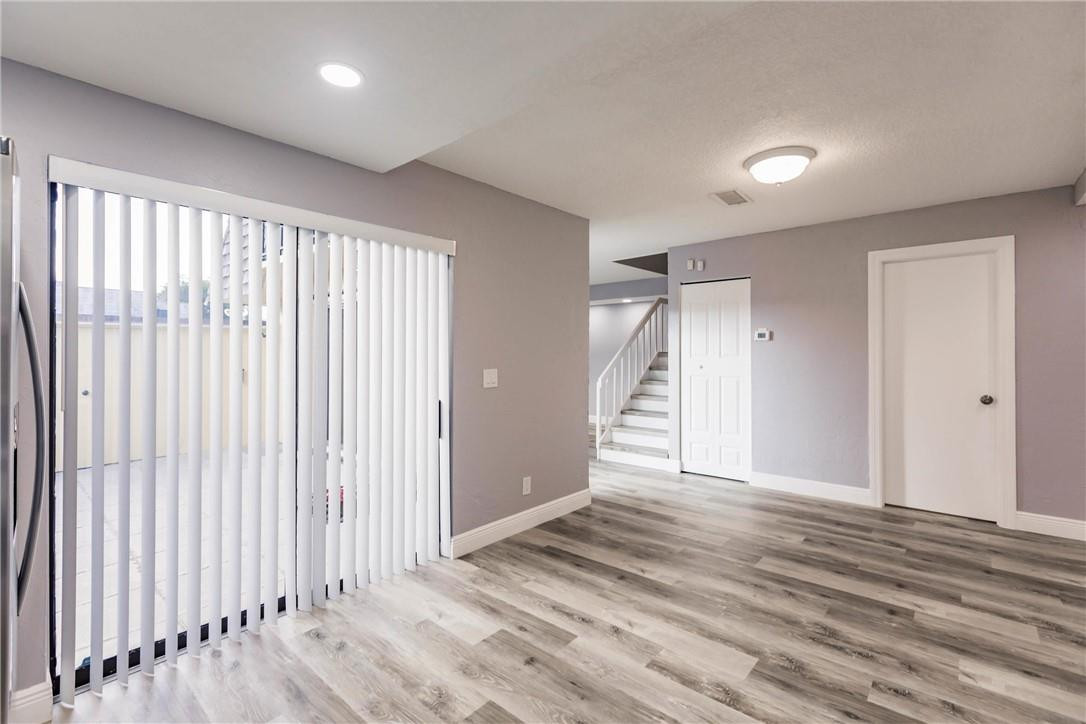 209 Woodland Road Palm Springs, FL 33461 - Photo 11 of 23 an empty room with wooden floor and windows