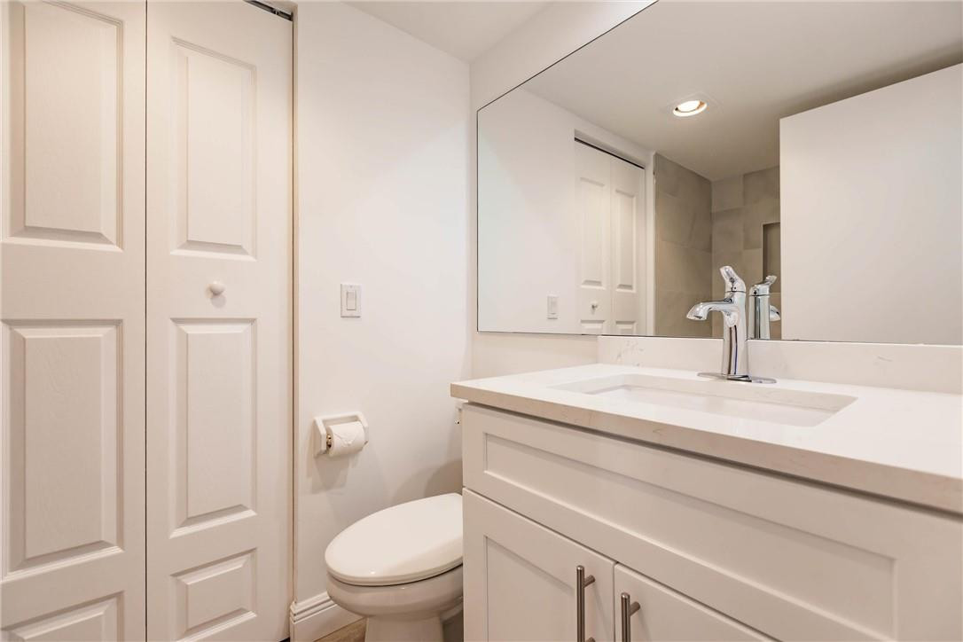209 Woodland Road Palm Springs, FL 33461 - Photo 14 of 23 a bathroom with a granite countertop toilet sink and a mirror