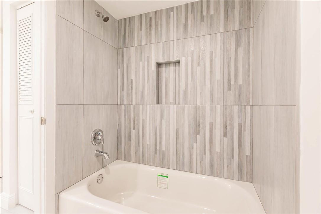 209 Woodland Road Palm Springs, FL 33461 - Photo 20 of 23 a bathroom with a bathtub and a shower curtain