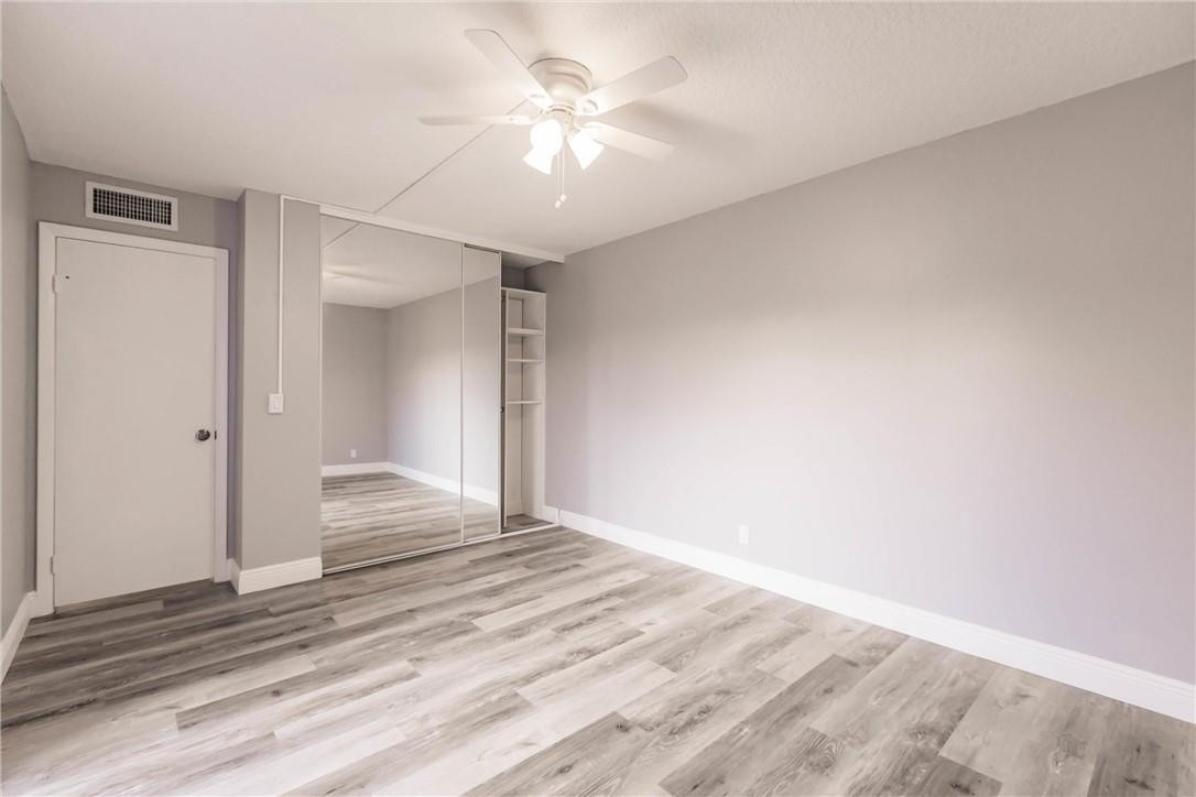 209 Woodland Road Palm Springs, FL 33461 - Photo 23 of 23 a view of a livingroom with wooden floor and a ceiling fan