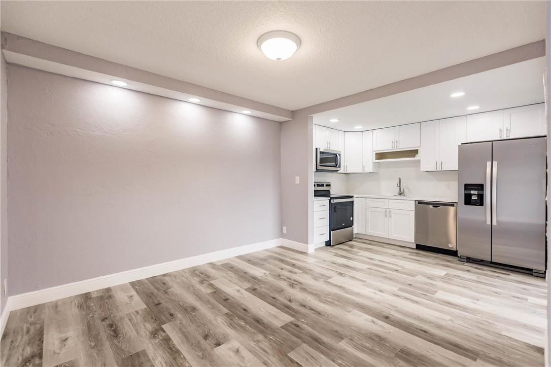 209 Woodland Road Palm Springs, FL 33461 - Photo 8 of 23 a kitchen with refrigerator cabinets and wooden floor