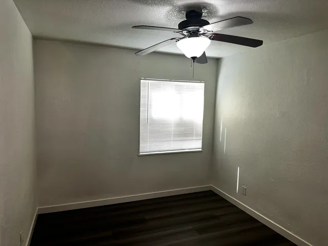 a view of empty room with wooden floor