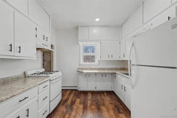 a kitchen with white cabinets and white appliances