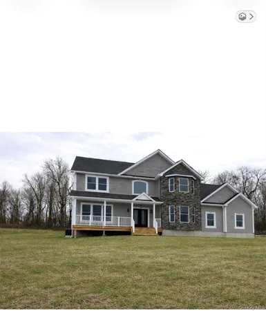 a view of a big house with a big yard and large trees