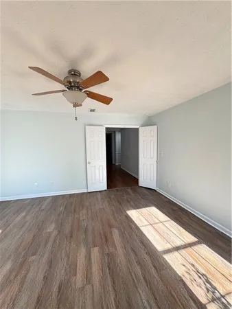 an empty room with wooden floor and windows