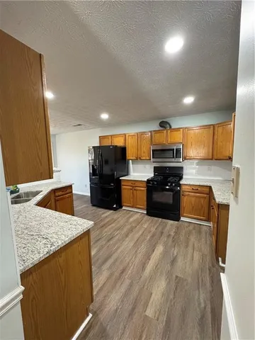 a kitchen with stainless steel appliances kitchen island granite countertop a stove and a sink