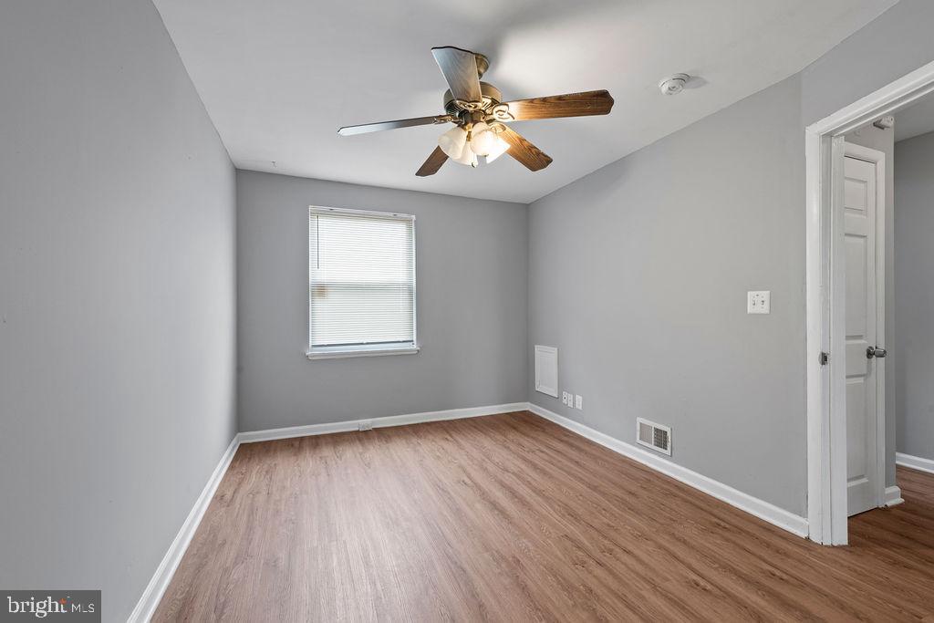 7308 Berkshire Road Baltimore, MD 21224 - Photo 19 of 40 a view of an empty room with wooden floor and a window