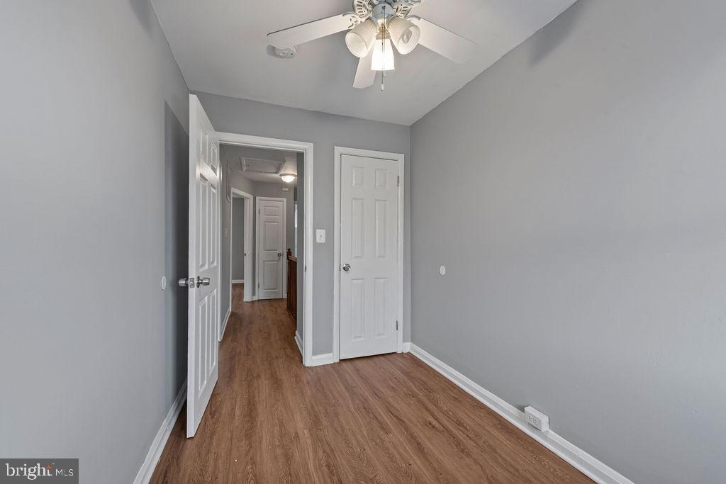 7308 Berkshire Road Baltimore, MD 21224 - Photo 22 of 40 a view of a hallway with wooden floor and a chandelier