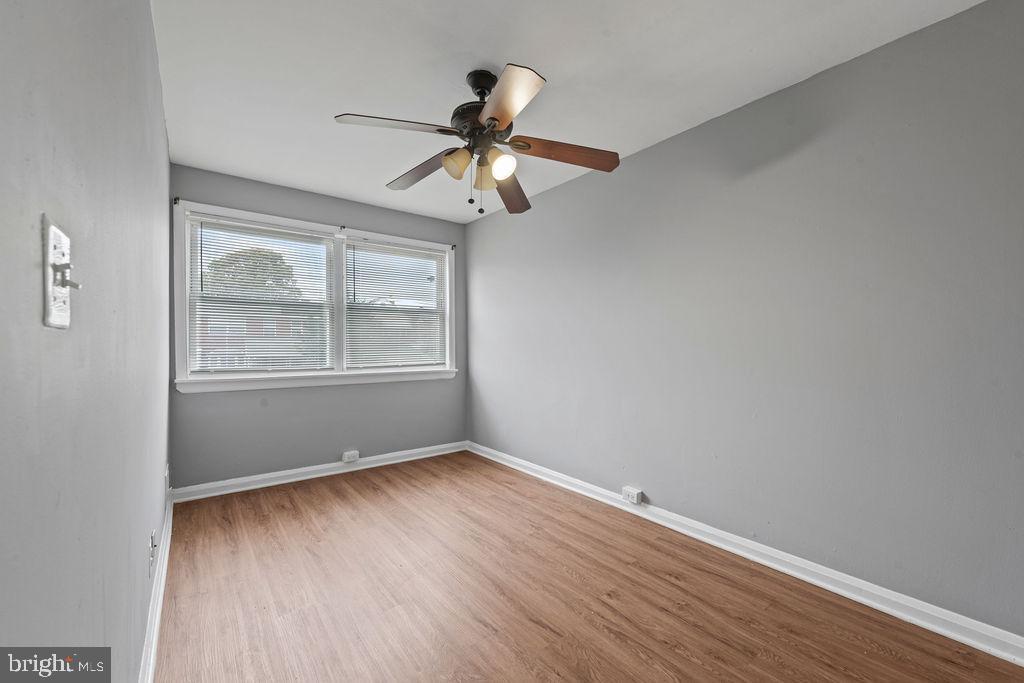 7308 Berkshire Road Baltimore, MD 21224 - Photo 26 of 40 a view of an empty room with wooden floor and a window