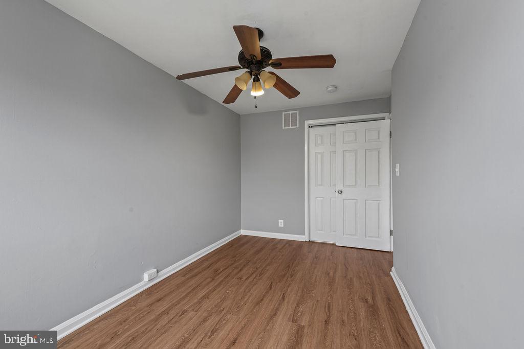7308 Berkshire Road Baltimore, MD 21224 - Photo 27 of 40 a view of an empty room with wooden floor and a ceiling fan
