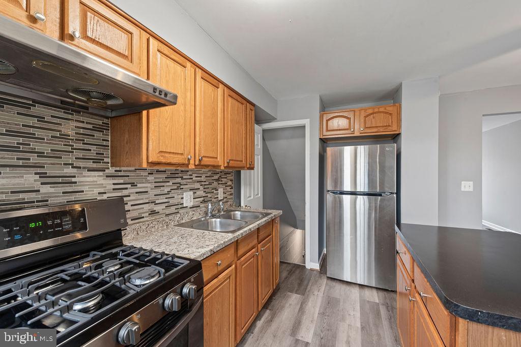 7308 Berkshire Road Baltimore, MD 21224 - Photo 6 of 40 a kitchen with stainless steel appliances granite countertop a stove a refrigerator and a stove