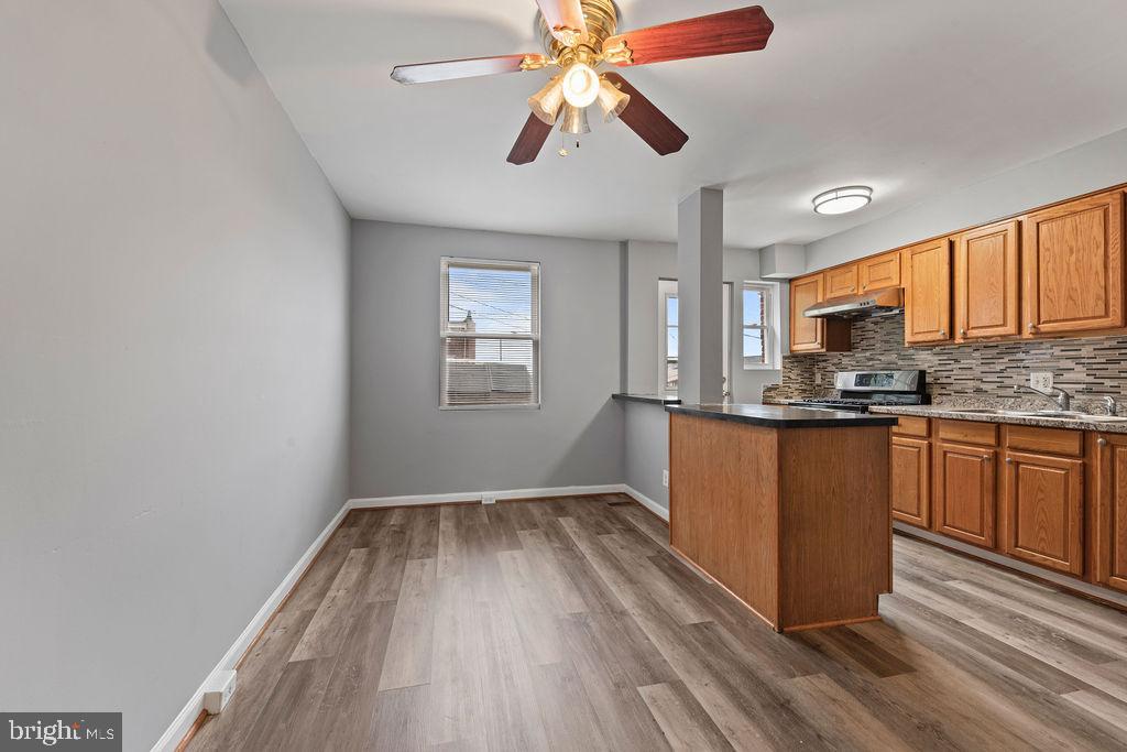 7308 Berkshire Road Baltimore, MD 21224 - Photo 7 of 40 a kitchen with granite countertop wooden floors granite counter tops and a window