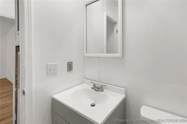 a bathroom with a sink a toilet and mirror