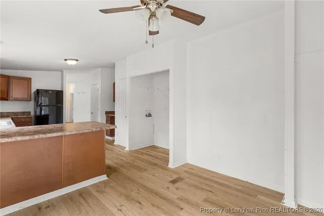 a living room with stainless steel appliances a wooden floor