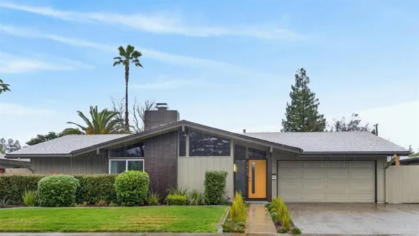 a front view of a house with a garden and plants