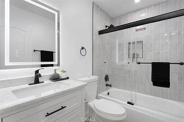 a bathroom with a toilet sink a mirror a shower and a bathtub