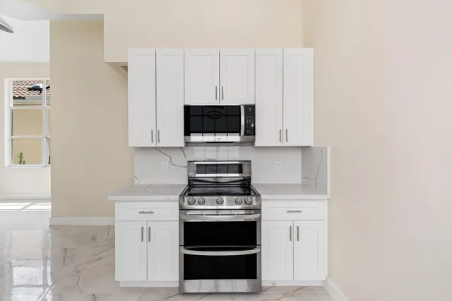 a kitchen with stainless steel appliances a stove and a microwave
