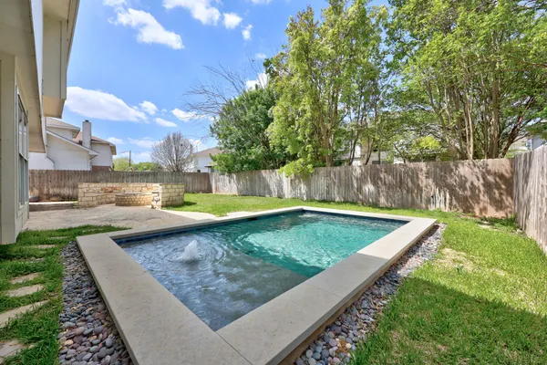 a view of a backyard with swimming pool