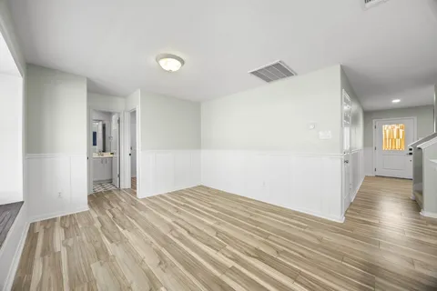 a view of a big room with wooden floor and windows
