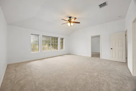 a view of a room with a ceiling fan and a window