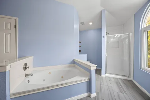 a bathroom with a tub a sink and a window